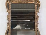 une photo d'un miroir doré posé sur une table blanche