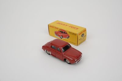 une petite voiture rouge à côté d'une boîte jaune sur une surface blanche