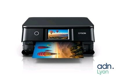 the printer is sitting on a white surface with a picture of a hot air balloon in the background
