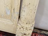 peeling paint on the door frame of a white painted bed