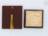 a small book with a gold bookmark on it next to a piece of paper