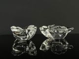 deux oiseaux en verre transparent posés sur une table noire