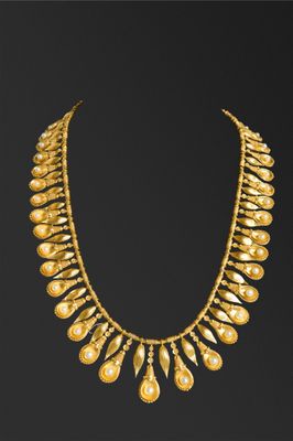 un collier en or orné de perles sur fond noir