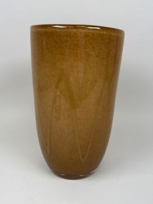 a brown cup that is sitting on a white surface