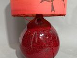 a red lamp that has a red shade on it