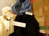 a pile of clothes and a box on a bed