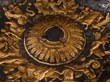 a black and gold plate with gold decorations on it
