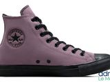 a close up of a pair of purple converses on a white background