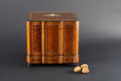 a small wooden cabinet with two nuts on the ground