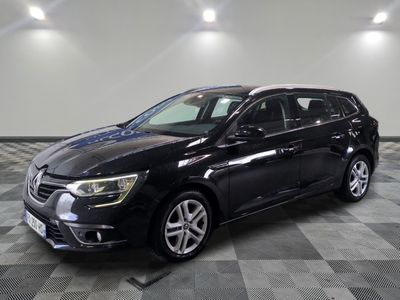 a black car is parked on a checkered floor in a garage