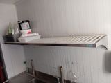 a sink in a kitchen with a shelf above it