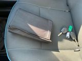 a car seat with a wallet, keys, and other items in it