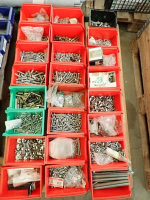 de nombreux types de vis et d'écrous dans des bacs rouges