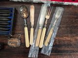 many different types of knives and spoons on the table