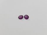 a pair of purple sapphires on a white surface