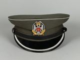 une casquette militaire ornée d'un insigne, posée sur une table