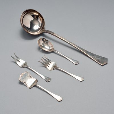 une cuillère, une fourchette et un repose-cuillère posés sur une table