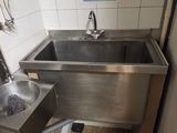 deux lavabos dans des toilettes publiques, avec une affiche accrochée au mur