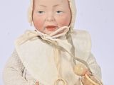 a baby doll that is sitting on the ground