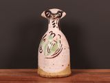 un vase blanc orné d'un motif vert et noir