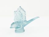 a glass bird that is sitting on top of a table