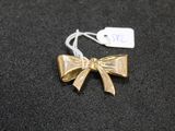 a gold bow with a tag on it on a black surface