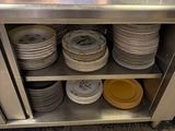 many plates stacked on a metal shelf in a kitchen
