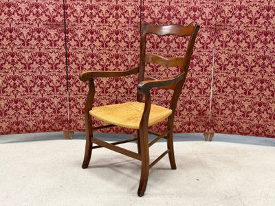 a wooden chair with a yellow seat in front of a red wall
