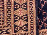 a close up of a rug with a cat on it ' s back
