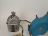 a blue bottle and a metal container sitting on a table