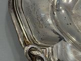 a silver plate with a bird on it sitting on a table