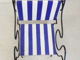 blue and white striped chair with black metal frame and arms