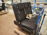 two seats that are sitting on a pallet in a warehouse