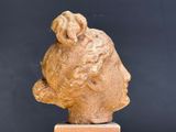 sculpture of a woman ' s head on a wooden base