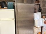 an image of a refrigerator and a refrigerator freezer in a basement