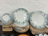many plates and bowls sitting on a table next to each other