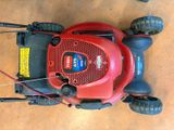 a red lawn mower that is sitting on the ground