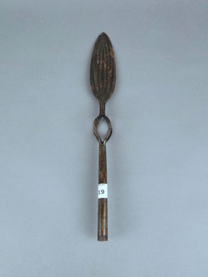 une vieille cuillère avec une étiquette, posée sur une table