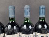 three bottles of wine are lined up on a table