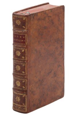 un vieux livre à la couverture brune posé sur une surface blanche