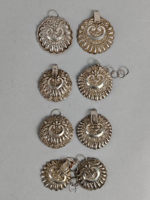 un ensemble de cinq pendentifs argentés sur un fond blanc