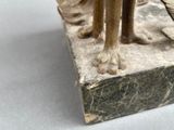 a bronze statue of a woman holding a fish