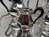 three silver teapots sitting on a silver tray