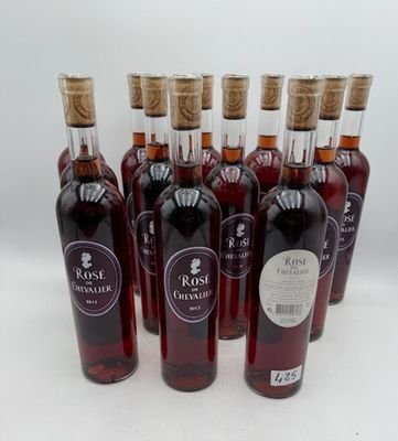 six bouteilles de vin sont alignées sur une surface blanche
