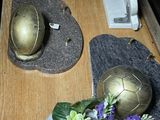 a wooden table with a vase of flowers and a gold ball on it