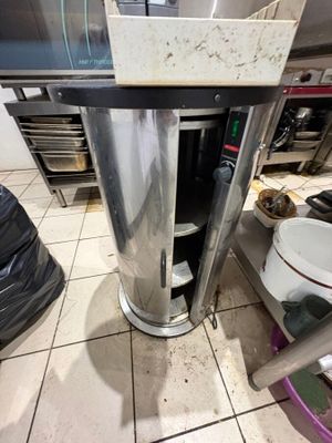 an image of a kitchen with a stove and a trash can