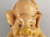 a ceramic pig that is sitting on the ground