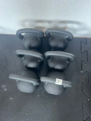 quatre poids de bouilloire noirs posés sur un tapis noir au sol