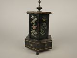 une petite boîte noire décorée de fleurs peintes