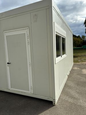 un petit bâtiment blanc situé dans un parking
